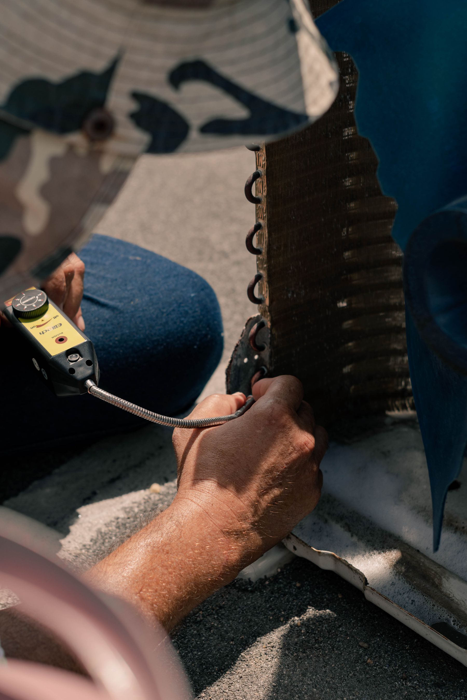 Technician checking an air-conditioning coil with a handheld meter